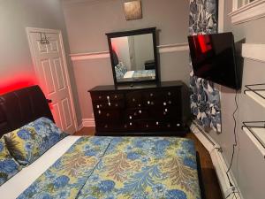 a bedroom with a bed and a dresser with a mirror at Grove#9 in Irvington
