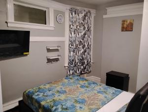 a small bedroom with a bed and a television at Grove#9 in Irvington