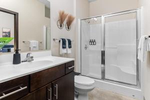 a bathroom with a shower and a toilet and a sink at 2KBD2BA Steps from Target Center+GYM+KTCHN+LNDRY in Minneapolis +50 photos