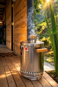 a metal tub with smoke coming out of it on a porch at Refugio La Tángara del Río in Cocorná
