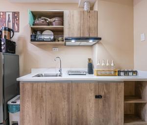 a kitchen with wooden cabinets and a sink at Mactan Cebu Cozy Relaxing Studio with Pool View Balcony in Pajak