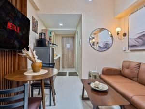 a living room with a couch and a table at Mactan Cebu Cozy Relaxing Studio with Pool View Balcony in Pajak
