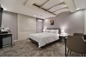 a bedroom with a large white bed and chairs at Page 9 Hotel in Seoul +4 photos