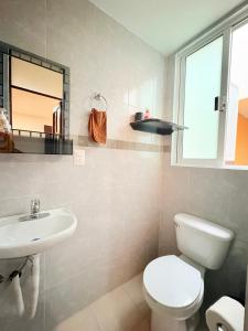 a bathroom with a toilet and a sink and a mirror at Hospedaje La Gardenia in Zacatlán +7 photos