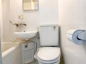 a white bathroom with a toilet and a sink at スマートホテル福島駅前店 in Fukushima