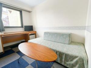 a room with a desk and a bed and a table at スマートホテル福島駅前店 in Fukushima