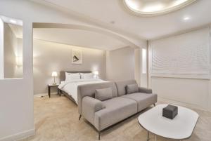 a bedroom with a bed and a couch and a table at Page 9 Hotel in Seoul