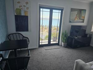 a living room with a television and a sliding glass door at A La Roslyn in Napier
