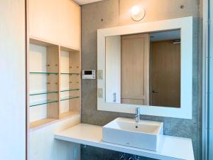 a bathroom with a sink and a mirror at Private Villa The Beach AMAMI in Tatsugo