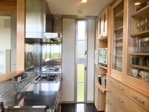 a kitchen with a stove and a counter top at Private Villa The Beach AMAMI in Tatsugo +26 photos