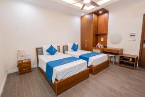 a hotel room with two beds and a desk at Royal Louis Hotel in Hanoi +63 photos