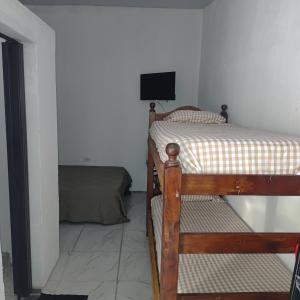 a bedroom with two bunk beds and a television at Hospedaje El Colibri in Ezeiza