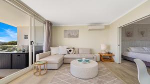 a living room with a couch and a bed at Peacock Hideaway in Ettalong Beach