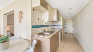 a small kitchen with a sink and a table at Peacock Hideaway in Ettalong Beach
