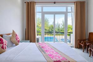 a bedroom with a bed and a large window at Bason Hotel Long Hải in Long Hai +112 photos