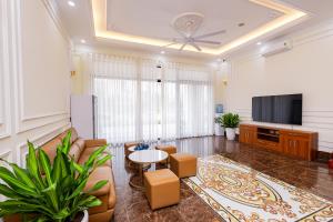 a living room with a tv and a table and chairs at Royal Louis Hotel in Hanoi