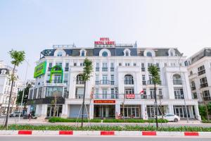 a white building with a sign on top of it at Royal Louis Hotel in Hanoi
