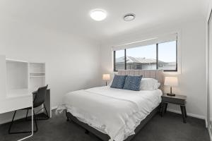 a bedroom with a bed and a desk and a window at The Lavender House in Gledswood Hills