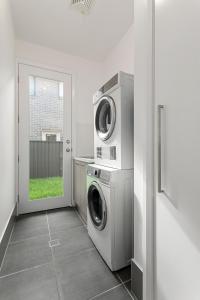 a laundry room with a washing machine and a window at The Lavender House in Gledswood Hills