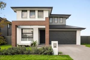 a brick house with a black garage at The Lavender House in Gledswood Hills