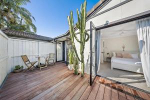 a deck with a table and a couch at Barefoot at Sunrise Guest Suite in Byron Bay