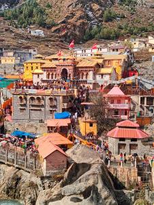 a group of buildings on a hill with a crowd of people at Hotel vivekanand in Badrinath