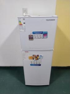 a white refrigerator freezer sitting next to a wall at Módulos ate 3 in Punta Alta