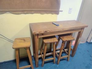 a wooden table and stools with a remote control on top at Módulos ate 3 in Punta Alta +1 photo