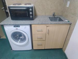 a kitchen with a microwave and a washing machine at Módulos ate 3 in Punta Alta