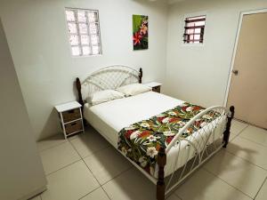 a bedroom with a bed with a white bedspread at Bua Bed & Breakfast in Nadi +15 photos