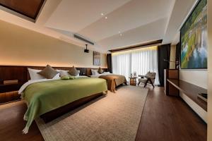 a hotel room with two beds and a large window at MiLO Hearth米罗设计民宿 张家界天门山索道店 in Zhangjiajie