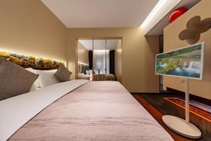 a bedroom with a large bed and a tv at MiLO Hearth米罗设计民宿 张家界天门山索道店 in Zhangjiajie