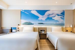 two beds in a room with a view of the ocean at Atour Hotel Jining High-tech Zone in Jining +54 photos