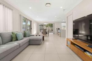 a living room with a couch and a flat screen tv at Manning the Waves in Kiama