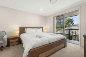a bedroom with a large bed and a window at Manning the Waves in Kiama