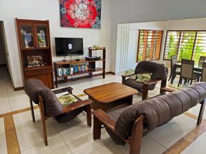a living room with a couch and chairs and a tv at Bua Bed & Breakfast in Nadi