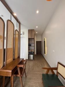 a living room with a wooden table and a kitchen at La May Boutique hotel in Ninh Binh