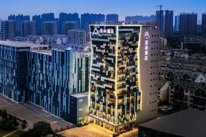 a tall building with aania sign on it in a city at Atour Hotel Jining High-tech Zone in Jining