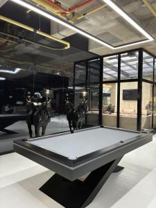 a ping pong table in a room with statues of horses at Modern studio apartment Parque de la 93 in Bogotá