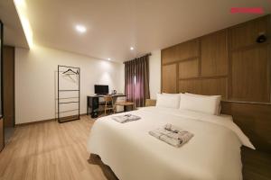 a hotel room with a large bed and a desk at 월호텔 in Cheonan