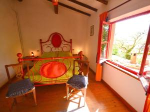 a bedroom with a bed and two chairs and a window at Belvilla by OYO Cinque Tetti in San Marcello Pistoiese