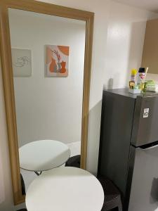 a room with two white stools and a refrigerator at LJ CCC CozyNest at 32 Cebu Fast Wifi Netflix You tube in Cebu City +12 photos