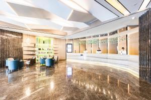 a lobby with a bar and tables and chairs at Atour Hotel Jining High-tech Zone in Jining
