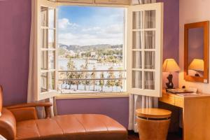 ein Wohnzimmer mit einem großen Fenster mit Aussicht in der Unterkunft TTC Hotel - Ngoc Lan in Da Lat