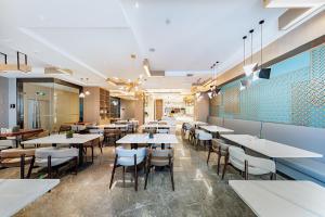 a dining room with white tables and chairs at Atour Hotel Jining High-tech Zone in Jining
