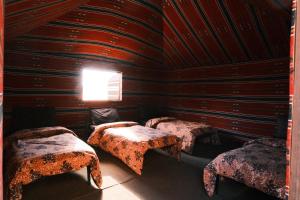 a room with two beds in a wooden room at Wadi Rum Magic Nature Camp in Wadi Rum +63 photos