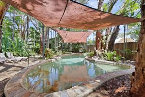 a swimming pool in a yard with a hammock over it at Comfort Resort Blue Pacific in Mackay