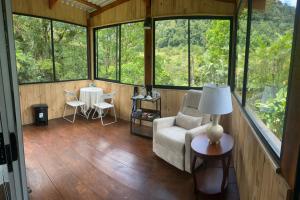 a room with a couch and a table and windows at Blue Morpho Lodge & Spa in Bajos del Toro