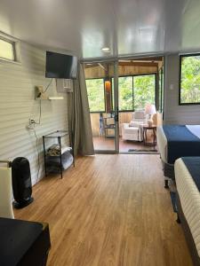 a bedroom with a bed and a living room with a tv at Blue Morpho Lodge & Spa in Bajos del Toro