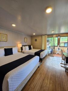 a hotel room with two beds and a balcony at Blue Morpho Lodge & Spa in Bajos del Toro
